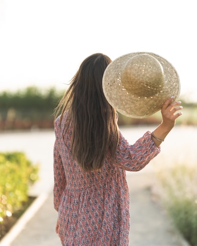 Woman in red and blue long sleeve shirt in the daytime holding a white ball
